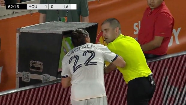 Martín Cáceres tocando a réferi mientras analiza el VAR